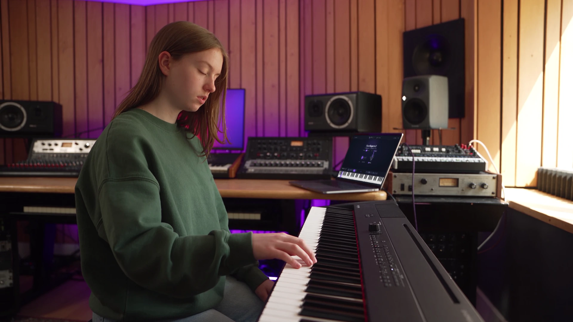 Une jeune apprenante travaillant un exercice à cinq doigts sur un clavier, dans un studio de musique